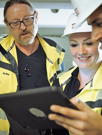 Zentrale Werte der Bauwerkserhaltung Foto von drei Personen mit Blick auf ein Tablet gerichtet